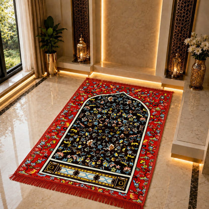 A rectangular prayer rug with a red floral border and a black central field decorated with multicolored floral motifs, placed on a polished marble floor in a luxurious interior setting.
