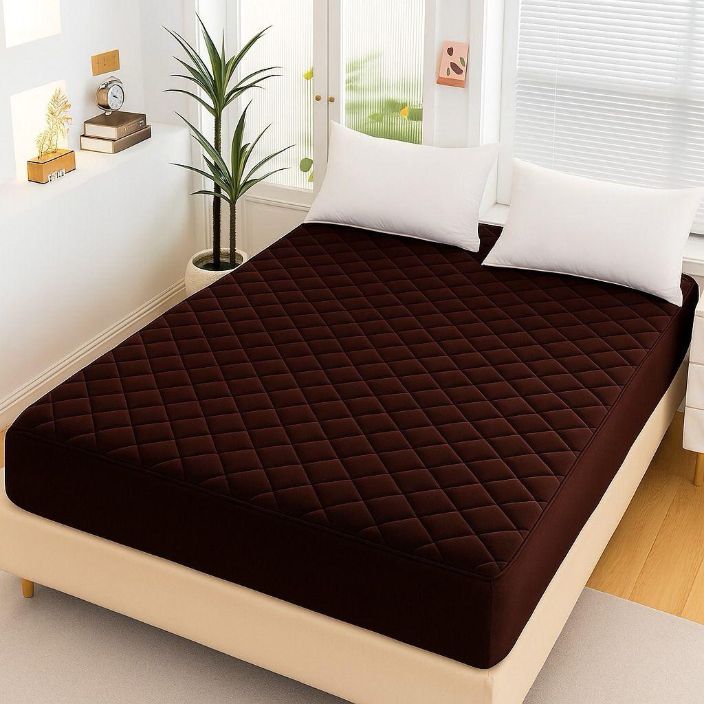 Chocolate Brown Quilted Waterproof Mattress Fitted Bed Sheet on modern beige bed with white pillows and indoor plant.