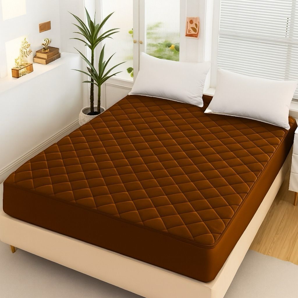 Chocolate Brown Quilted Waterproof Mattress Fitted Bed Sheet on modern beige bed with white pillows and indoor plant.