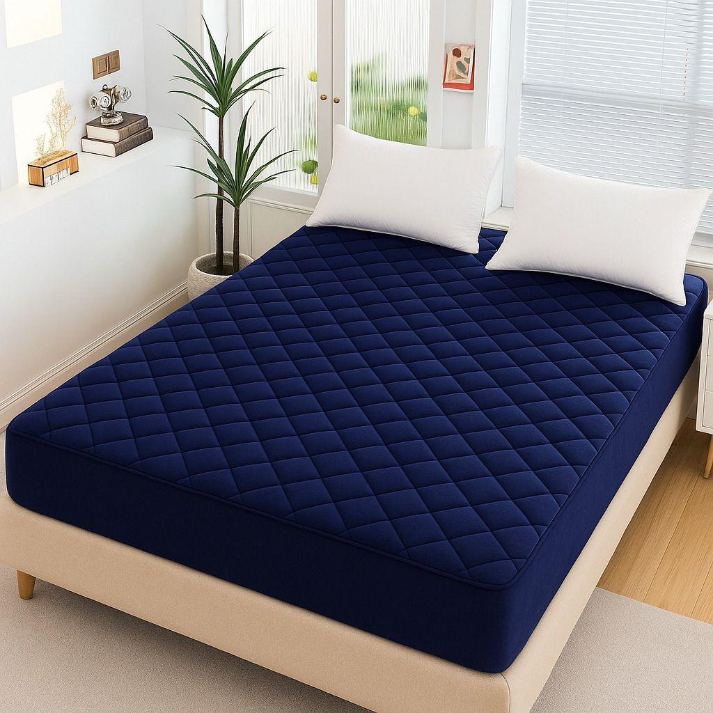 Elegant Dark Blue Quilted Waterproof Mattress Fitted Bed Sheet on minimalist bedroom setup with natural light.