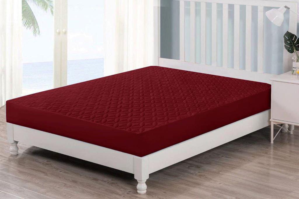 Maroon Quilted Waterproof Mattress Fitted Bed Sheet on contemporary beige bed with a potted plant by the window.