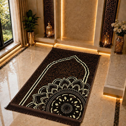 A rectangular prayer rug with a black background and cream-colored mandala and arch designs, laid out on a polished beige marble floor in a luxurious interior setting with warm ambient lighting.