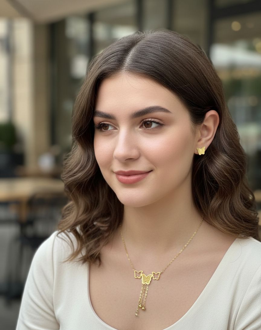 Woman wearing a gold necklace and earrings in an outdoor setting