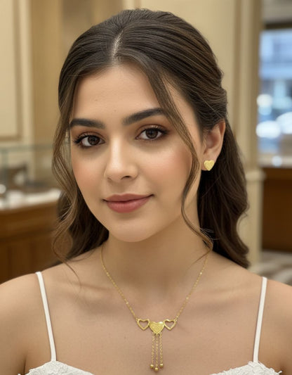 Woman wearing a gold necklace and earrings indoors