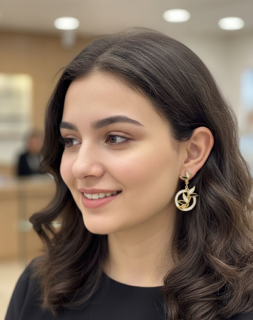 Woman wearing gold earrings with a blurred indoor background