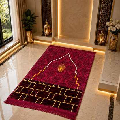 A rectangular prayer rug with fringe, featuring a deep magenta and burgundy patterned design with gold geometric accents, displayed on a polished marble floor in a luxurious interior setting.